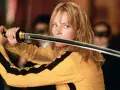 La Novia, con su icónico traje amarillo, desenvaina su katana. La banda sonora de Kill Bill resuena en esta escena de acción.