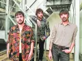 Los miembros de Lori Meyers posan juntos, con sus camisas estampadas y miradas serias, listos para su próxima actuación.