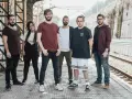 Los miembros de Itaca Band posan en una estación de tren abandonada, listos para su próxima aventura musical.