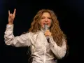 Shakira, deslumbrante con un traje plateado, canta en uno de los conciertos de Madrid, haciendo el signo de la paz.