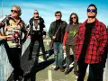 El germenes grupo posa en un puente, con ropa informal y gafas de sol.