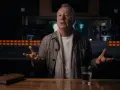 Jim Kerr, uno de los miembros de Simple Minds, habla en un estudio de grabación, con un libro y un vaso de agua sobre la mesa.