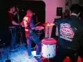 Un grupo de gatos locos en el escenario, tocando rock and roll con un contrabajo, batería y guitarra.