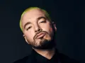 J Balvin, con su característico cabello verde vibrante, posa con una mirada intensa. Podría estar preparándose para un concierto en Madrid.
