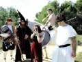 Un grupo peculiar, con atuendos que evocan a "wau y los arrrghs", posa con armas y un caballo blanco.