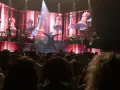 Un cantante en el escenario del 101 music festival, con una pantalla gigante de ajedrez de fondo.