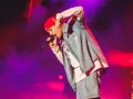 Un artista con gorra roja y ropa vaquera canta en un concierto boombastic Asturias.