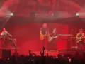 Izal en concierto en Madrid, banda en pleno show con luces rojas y público entregado.