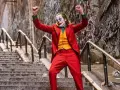 El Joker baila en las escaleras, su icónica banda sonora suena mientras celebra su caos.