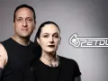 Un hombre y una mujer con tatuajes posan juntos. El logo de PETDUO aparece a la derecha.