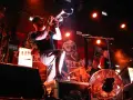 Músico con trompeta en un concierto de soria rock, con luces rojas y fondo de calaveras.