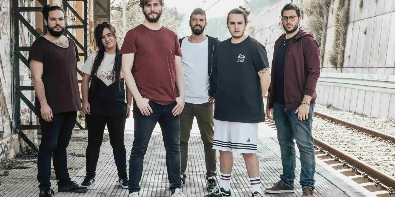 Los miembros de Itaca Band posan en una estación de tren abandonada, listos para su próxima aventura musical.
