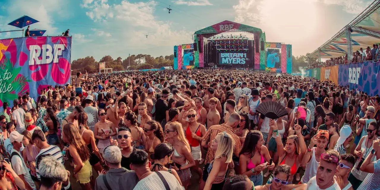 Multitud vibrante en un festival RBF, con el escenario de Bryant Myers al fondo. Una caja mágica de conciertos al aire libre.