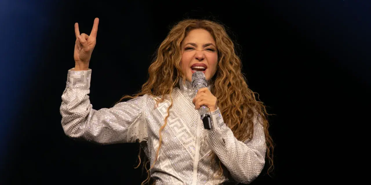 Shakira, deslumbrante con un traje plateado, canta en uno de los conciertos de Madrid, haciendo el signo de la paz.