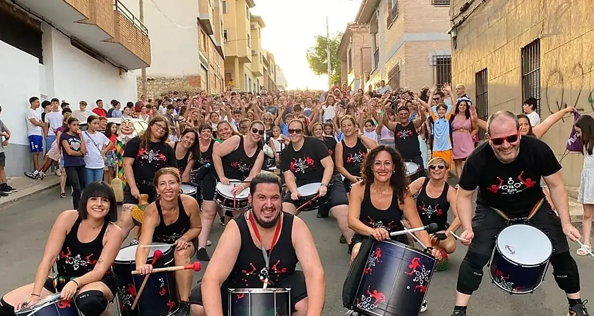 Grupo de percusionistas alegra las fiestas en España en septiembre. Multitud celebra en la calle.