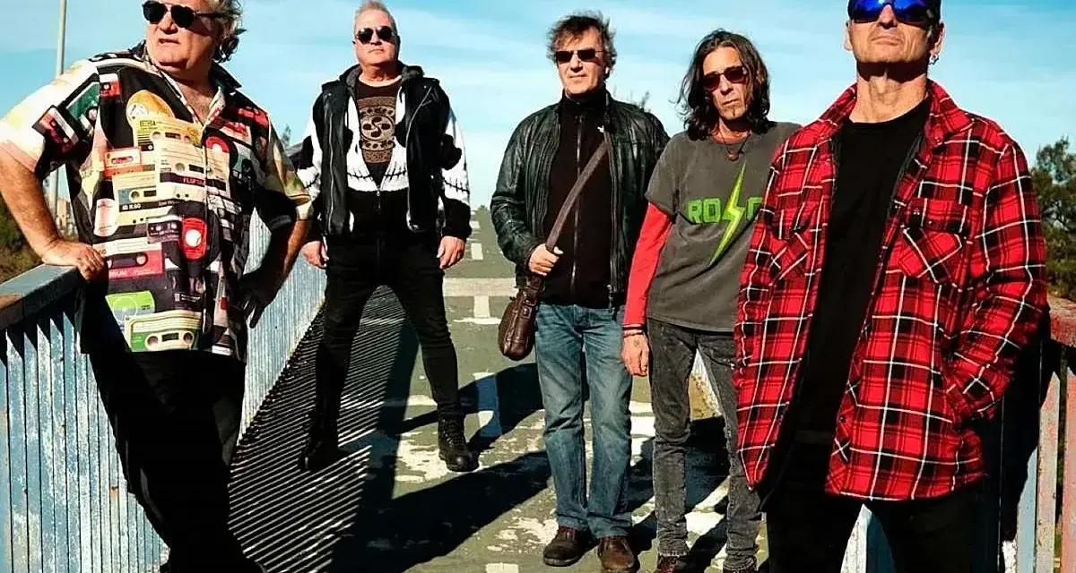 El germenes grupo posa en un puente, con ropa informal y gafas de sol.