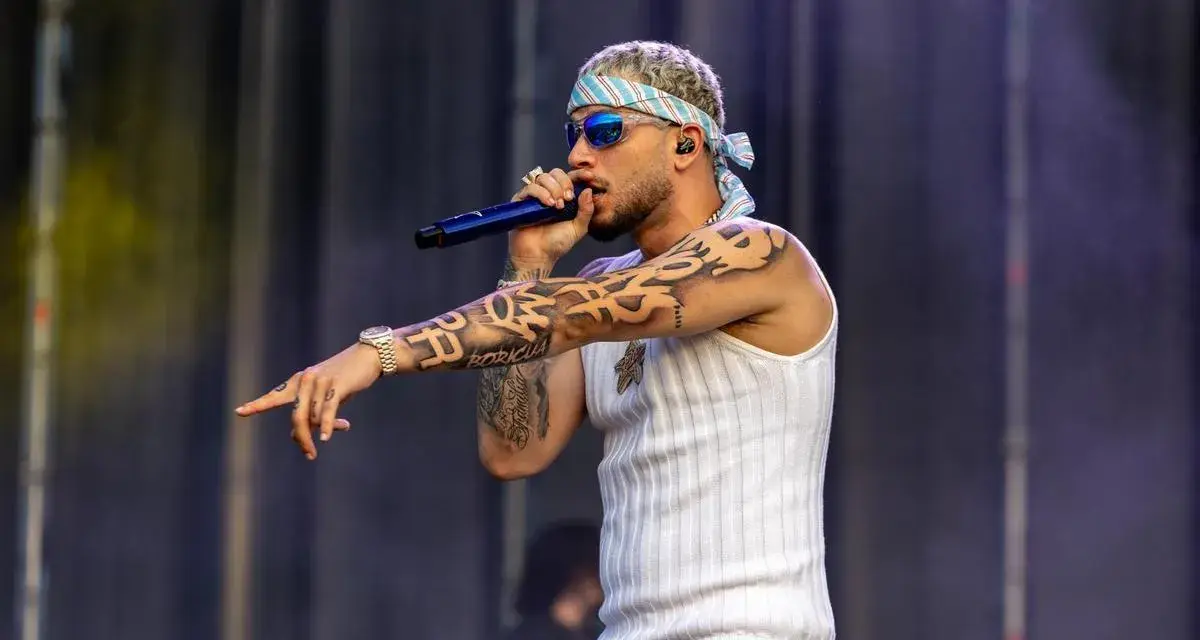El artista dei v Málaga, con tatuajes y bandana, canta en el escenario.