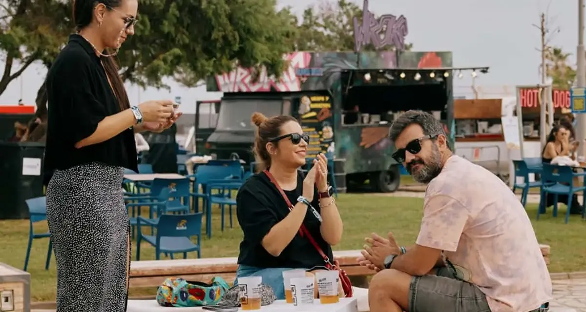 Amigos disfrutan del ambiente de rock en Valencia, con food trucks y música de fondo.