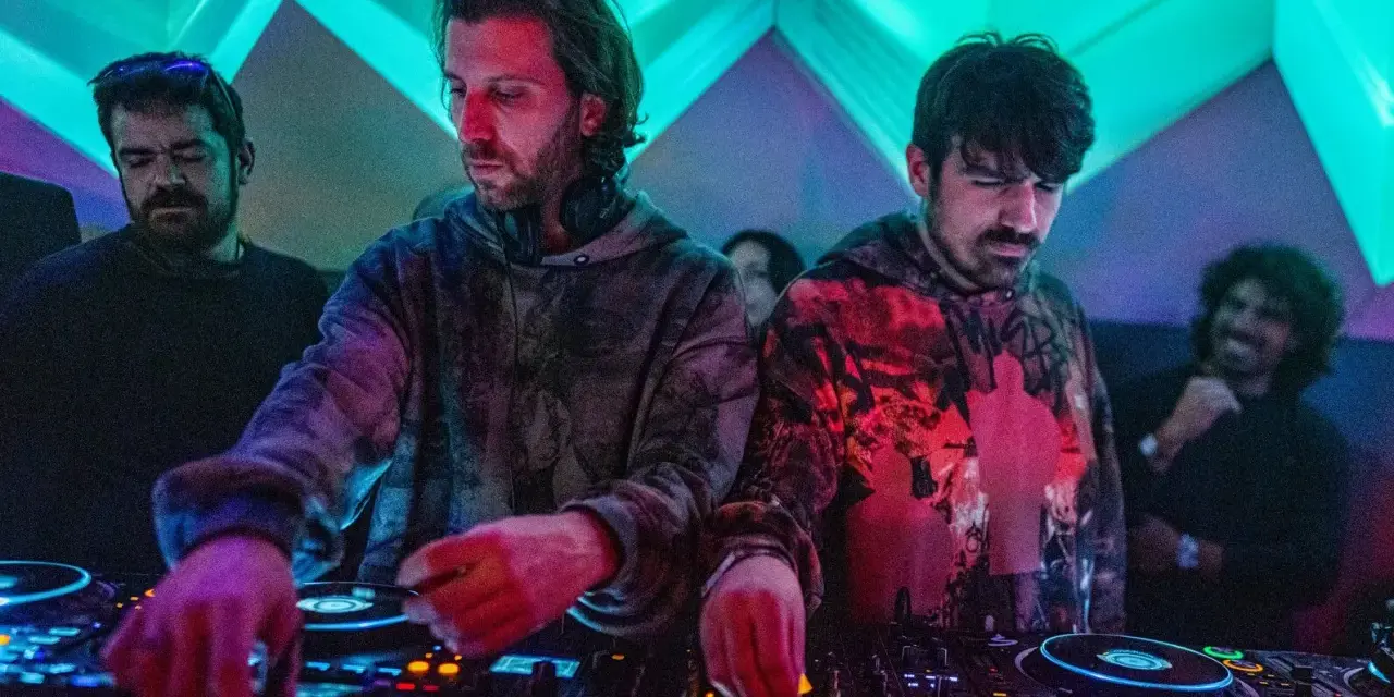 Los agentes del tiempo, DJs concentrados, manipulan las consolas bajo luces de neón, creando ritmos que desafían el tiempo.