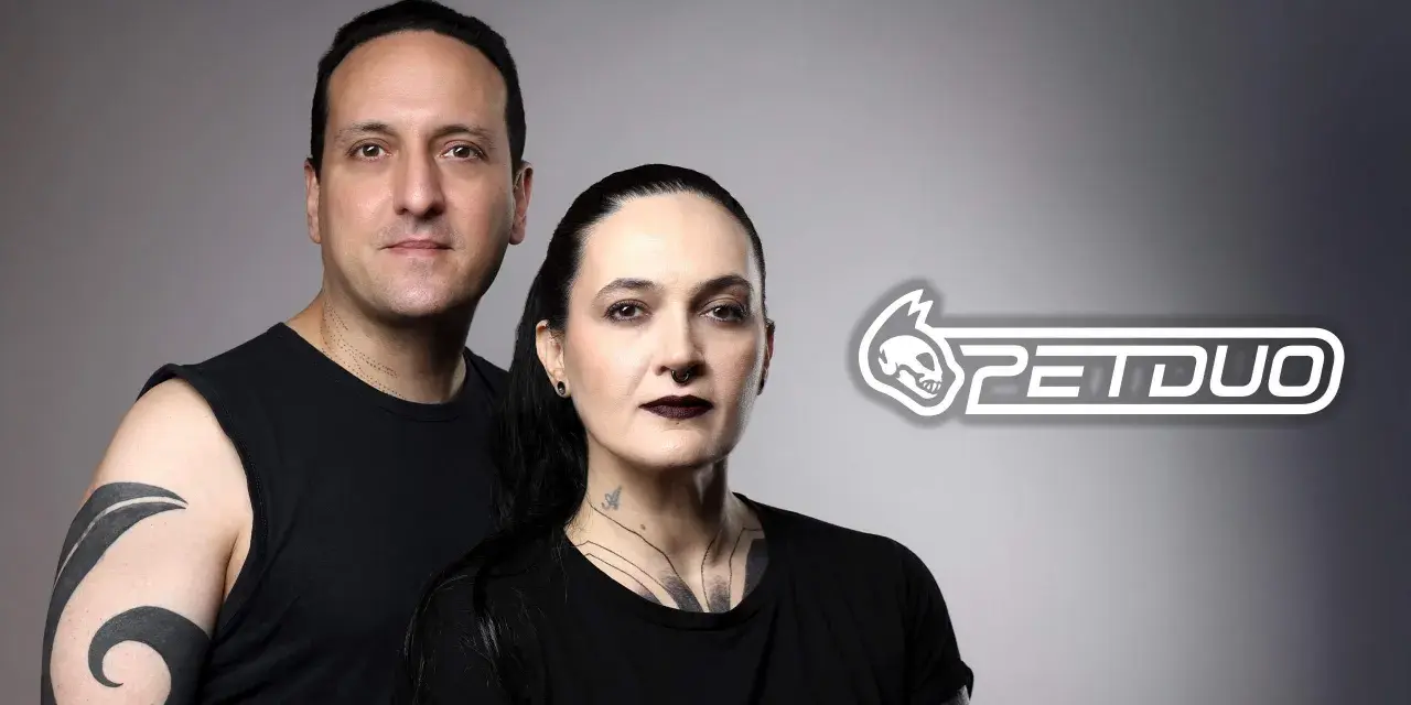 Un hombre y una mujer con tatuajes posan juntos. El logo de PETDUO aparece a la derecha.