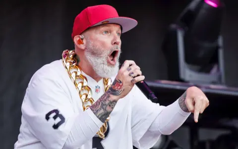 Fred Durst de Limp Bizkit, con gorra roja y cadena dorada, canta en un concierto en España.
