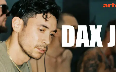 Primer plano de Dax J, DJ y productor de techno, con el logo de Arte.