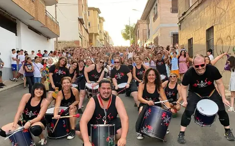 Grupo de percusionistas alegra las fiestas en España en septiembre. Multitud celebra en la calle.