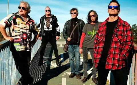 El germenes grupo posa en un puente, con ropa informal y gafas de sol.