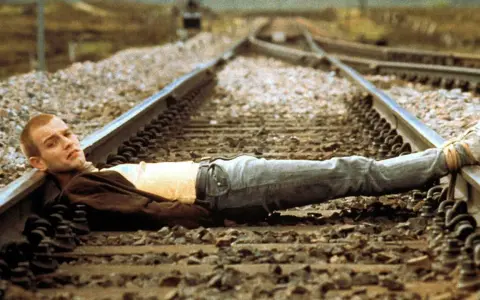 Un joven yace en las vías del tren, una imagen icónica de la banda sonora de Trainspotting.