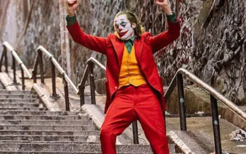 El Joker baila en las escaleras, su icónica banda sonora suena mientras celebra su caos.