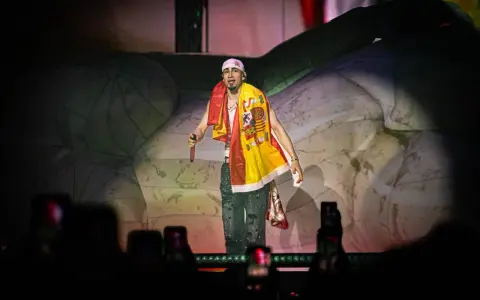 Artista con bandera española en el festival reggaeton Benidorm. El público graba con sus móviles.