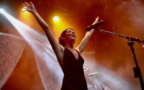 Mafalda Cardenal desata su energía en conciertos, con brazos al cielo y micrófono cerca.