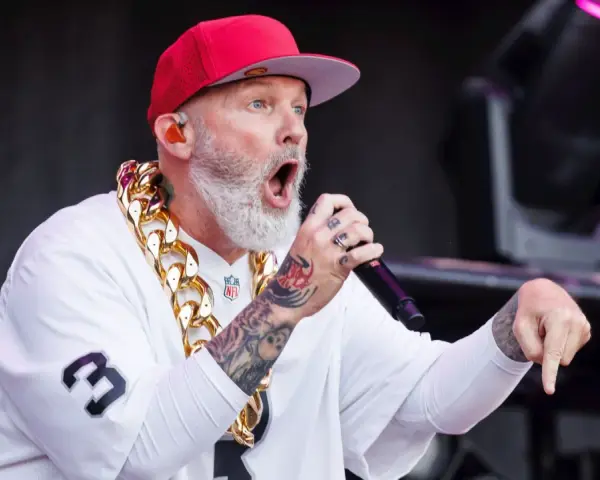 Fred Durst de Limp Bizkit, con gorra roja y cadena dorada, canta en un concierto en España.
