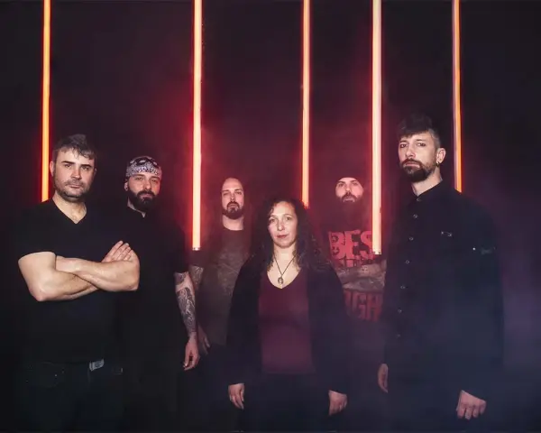 Cinco personas posan ante luces rojas. La banda Otero Brutal Fest lista para un concierto.