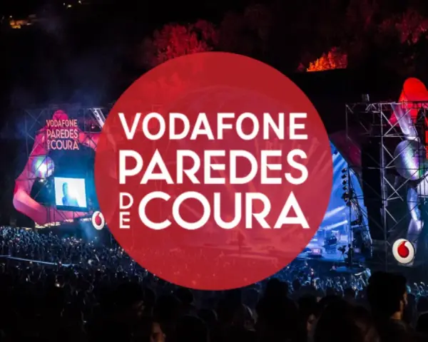 Gran multitud en el festival Vodafone Paredes de Coura, con luces y escenario iluminados.