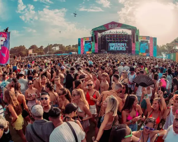Multitud vibrante en un festival RBF, con el escenario de Bryant Myers al fondo. Una caja mágica de conciertos al aire libre.