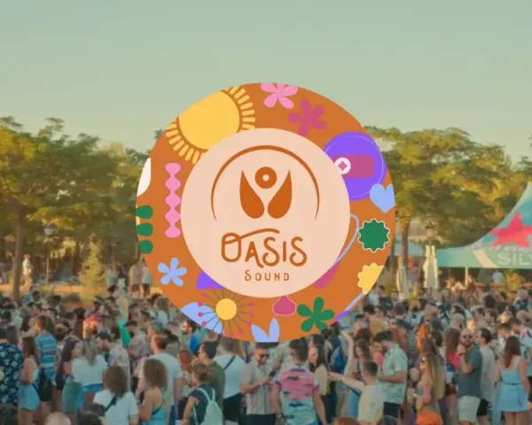 Multitud en un festival al aire libre, con un cartel circular de "Oasis Sound" y un toldo de Heineken Silver al fondo.
