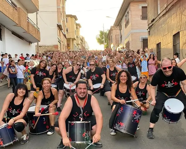 Grupo de percusionistas alegra las fiestas en España en septiembre. Multitud celebra en la calle.