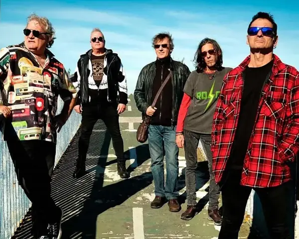 El germenes grupo posa en un puente, con ropa informal y gafas de sol.