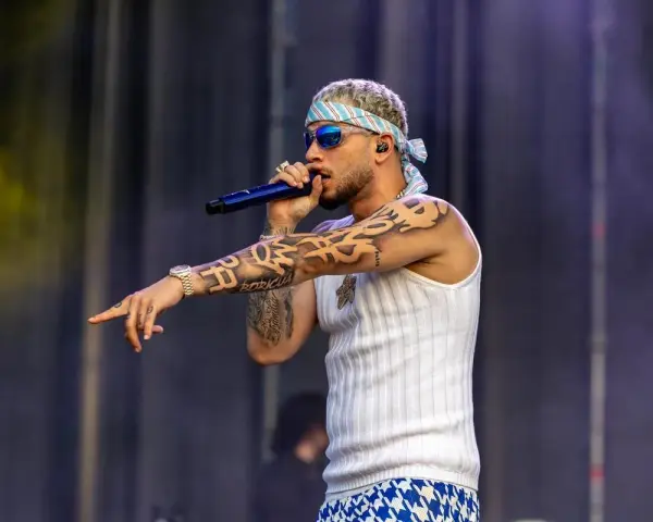 El artista dei v Málaga, con tatuajes y bandana, canta en el escenario.