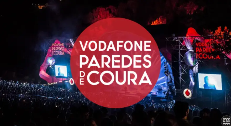 Gran multitud en el festival Vodafone Paredes de Coura, con luces y escenario iluminados.