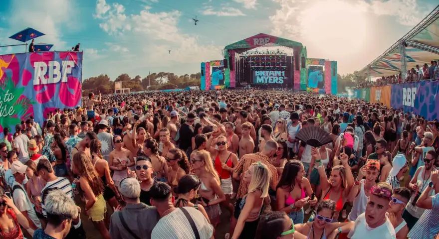 Multitud vibrante en un festival RBF, con el escenario de Bryant Myers al fondo. Una caja mágica de conciertos al aire libre.