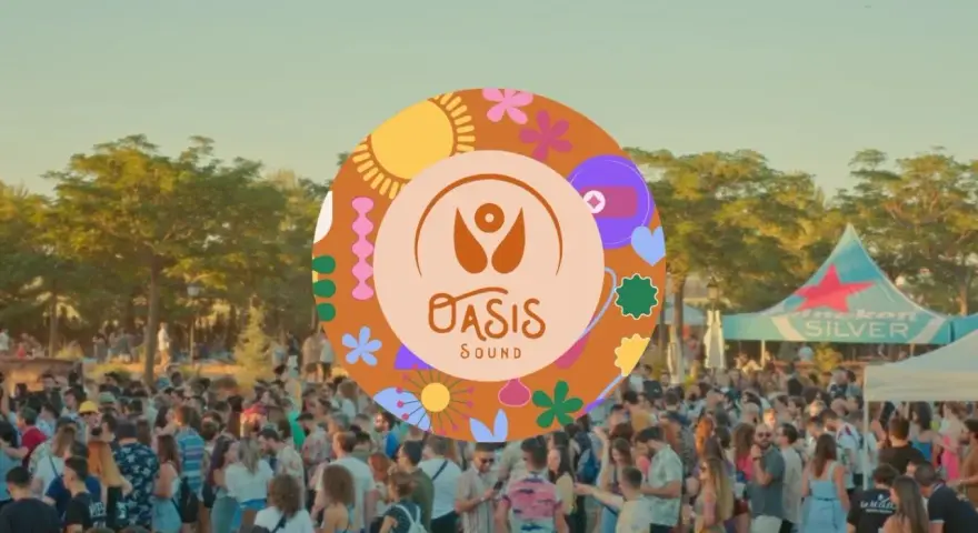 Multitud en un festival al aire libre, con un cartel circular de "Oasis Sound" y un toldo de Heineken Silver al fondo.