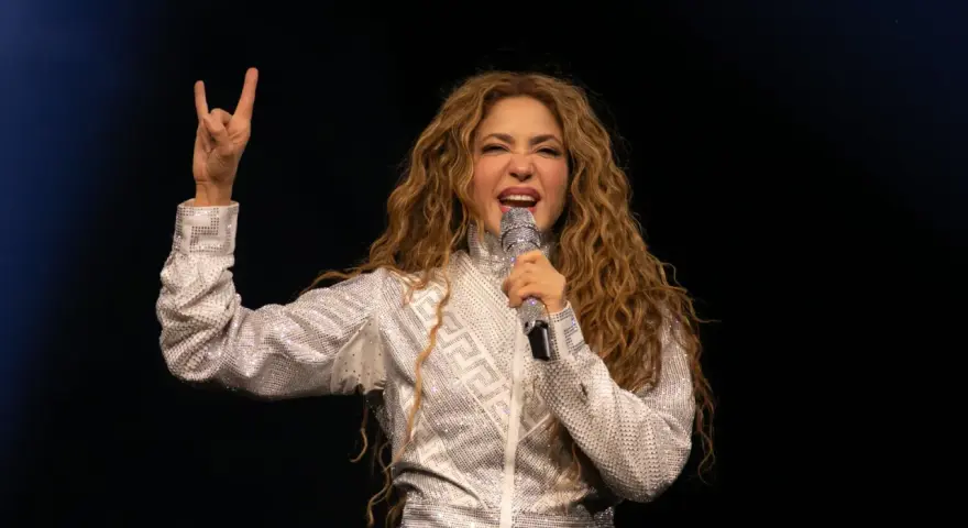 Shakira, deslumbrante con un traje plateado, canta en uno de los conciertos de Madrid, haciendo el signo de la paz.