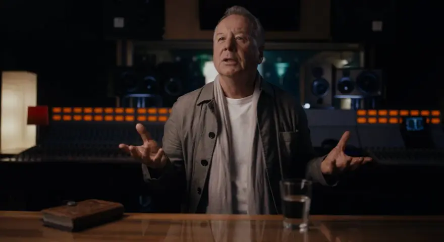 Jim Kerr, uno de los miembros de Simple Minds, habla en un estudio de grabación, con un libro y un vaso de agua sobre la mesa.