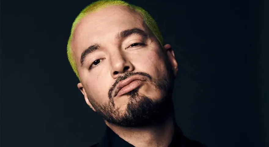 J Balvin, con su característico cabello verde vibrante, posa con una mirada intensa. Podría estar preparándose para un concierto en Madrid.