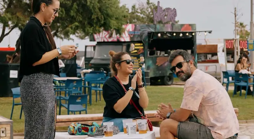 Amigos disfrutan del ambiente de rock en Valencia, con food trucks y música de fondo.