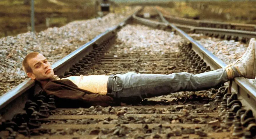 Un joven yace en las vías del tren, una imagen icónica de la banda sonora de Trainspotting.