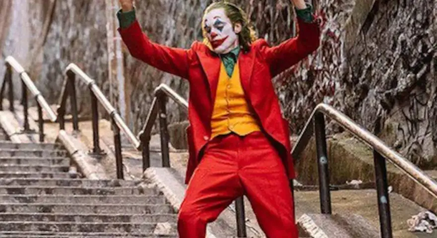 El Joker baila en las escaleras, su icónica banda sonora suena mientras celebra su caos.