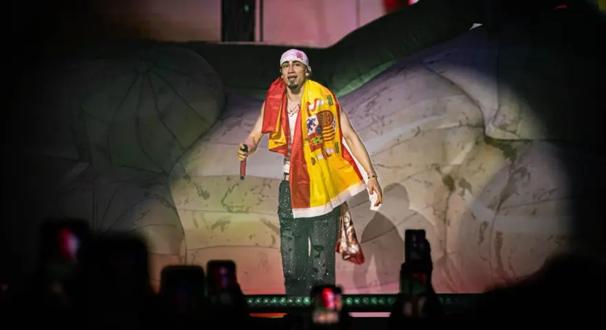 Artista con bandera española en el festival reggaeton Benidorm. El público graba con sus móviles.